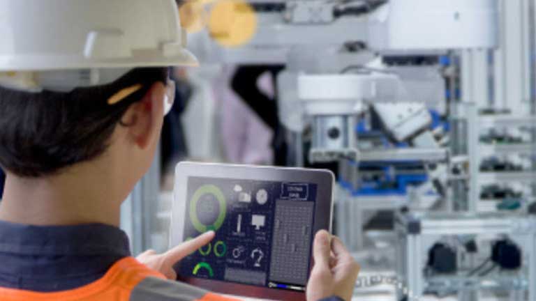 person using a tablet to control robotic machinery