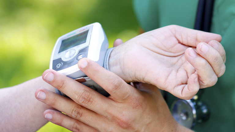 doctor checking patient's blood pressure with a wrist device